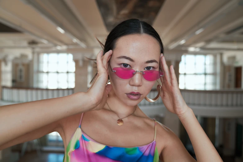 a woman is wearing sunglasses and looking at the camera