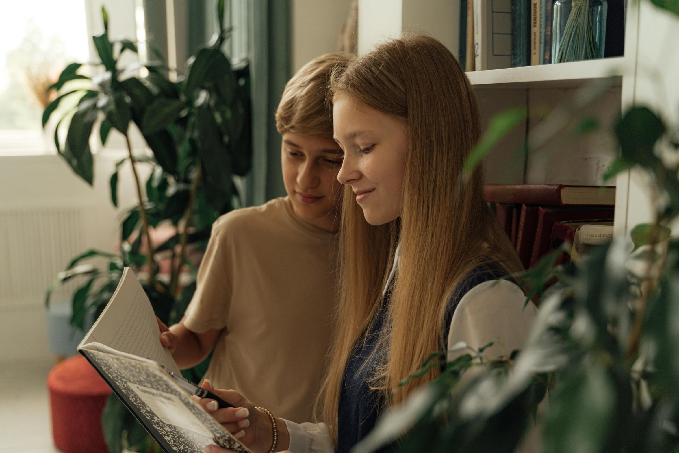 the two girls are both looking at the paper