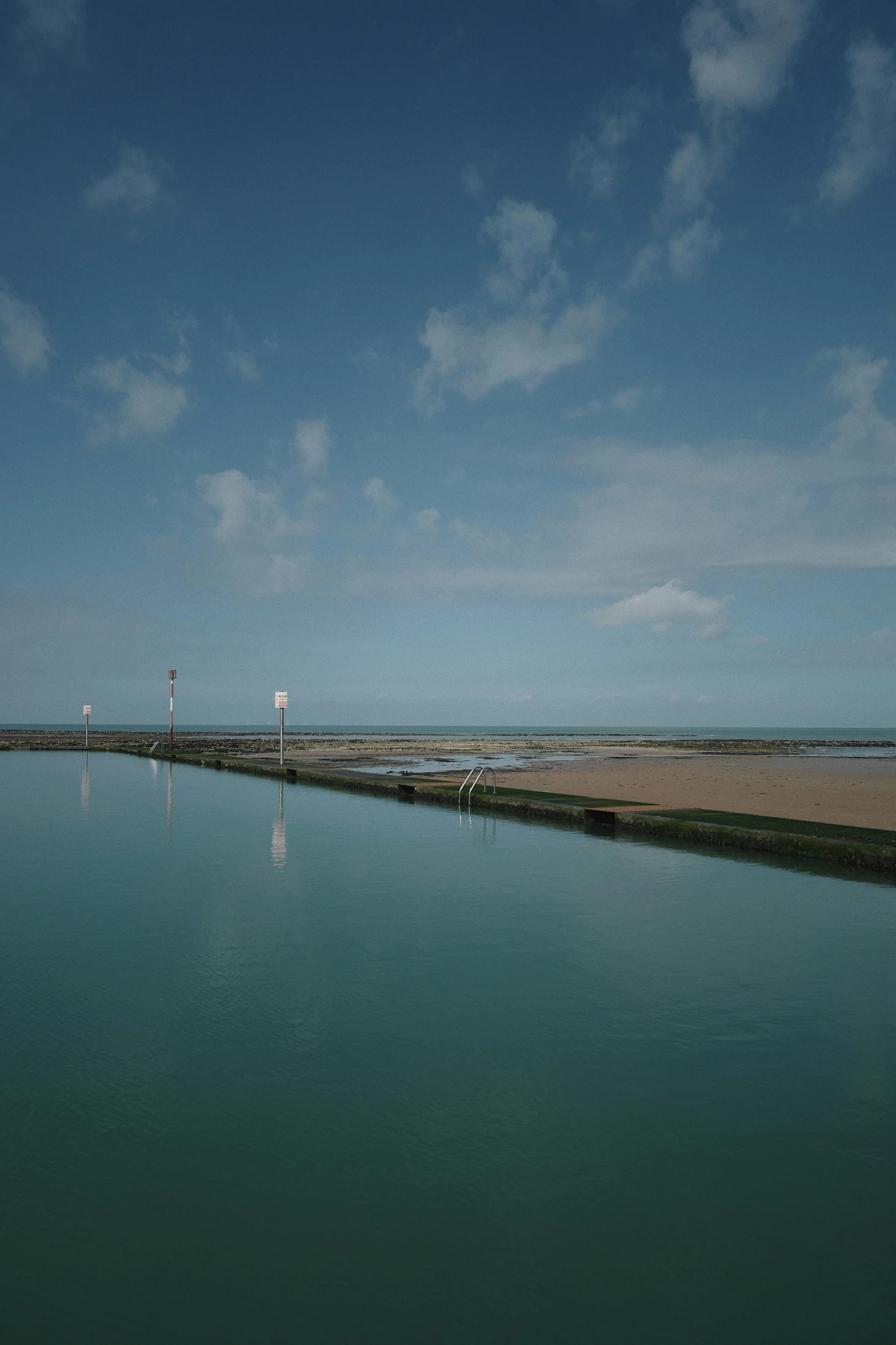 a calm body of water with boats in the distance