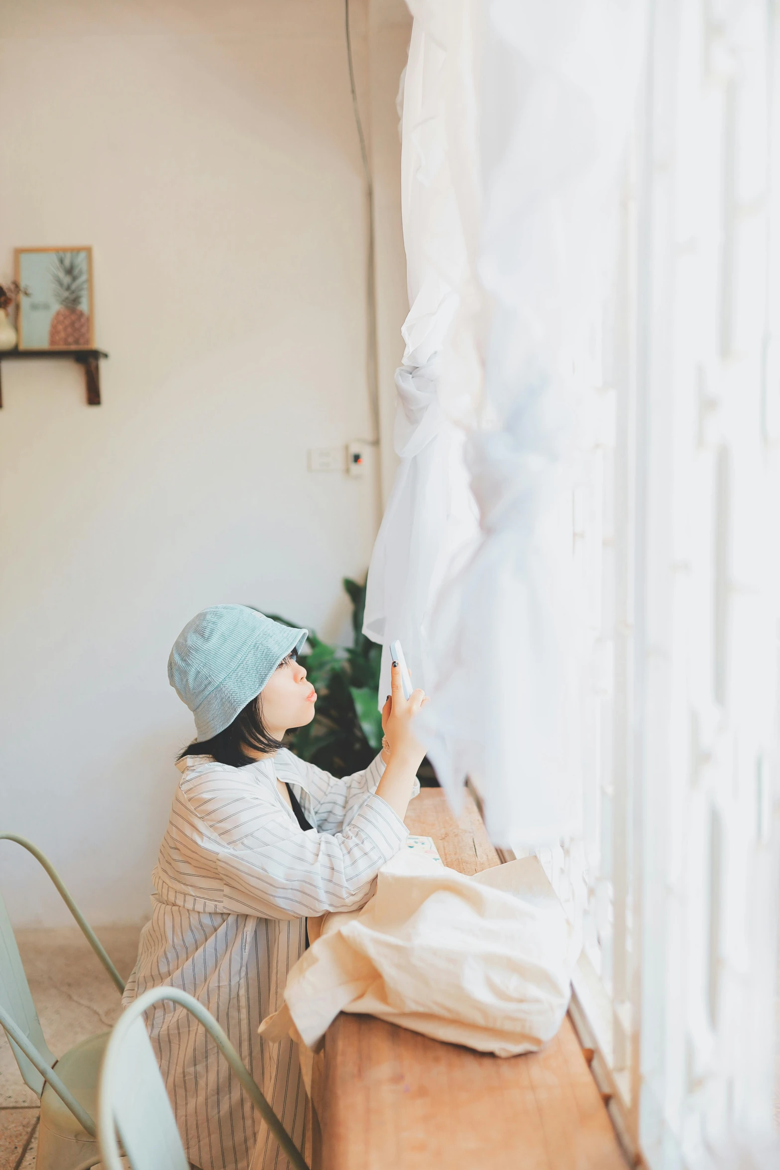 a woman sits on a couch, holding a hanger to dry her dress