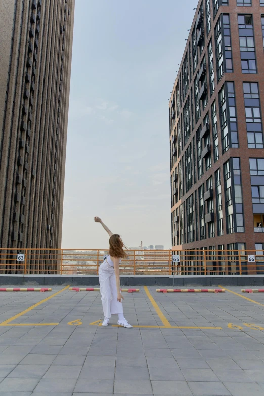 a woman in white dress standing next to large tall buildings