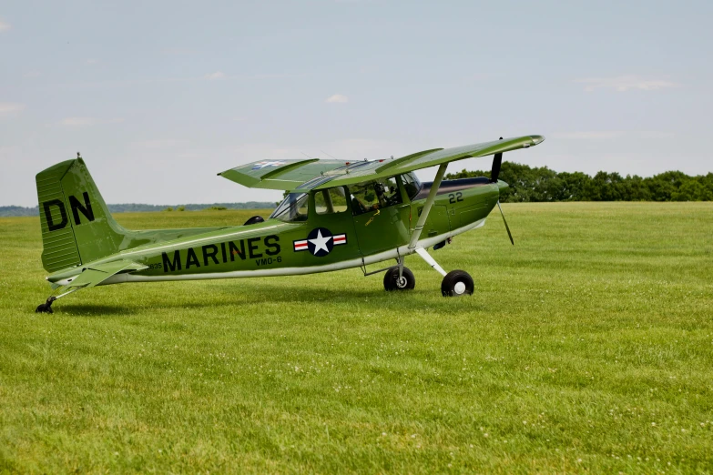 a green plane parked on top of a field