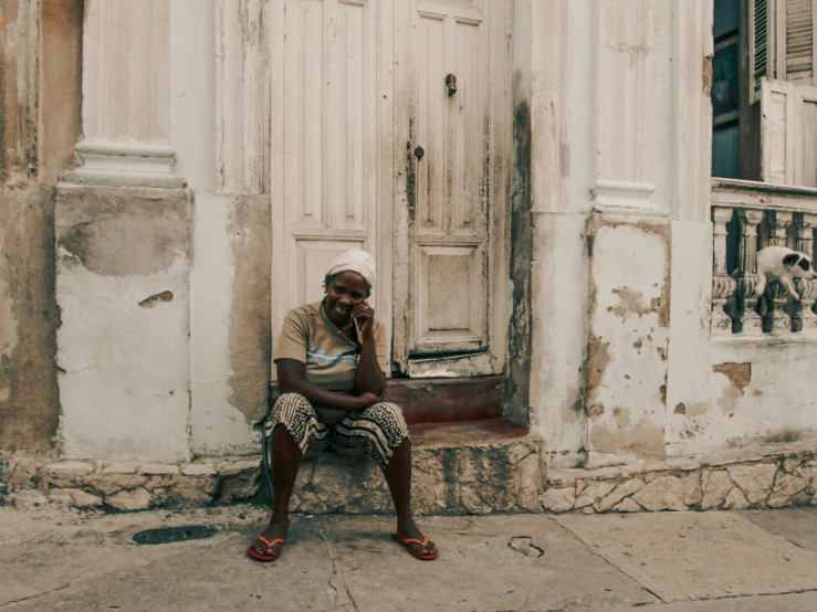 a person sits on a stone step next to a door