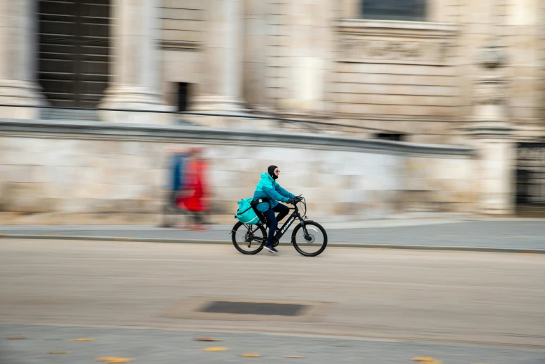 a man riding a bike down the road in the city