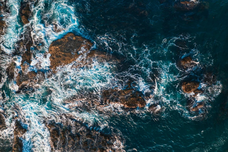 an overhead view of rocks and the ocean