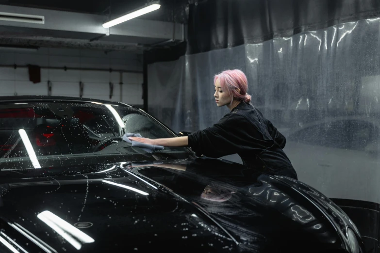 a person wearing a pink wig and getting the hood off of a car