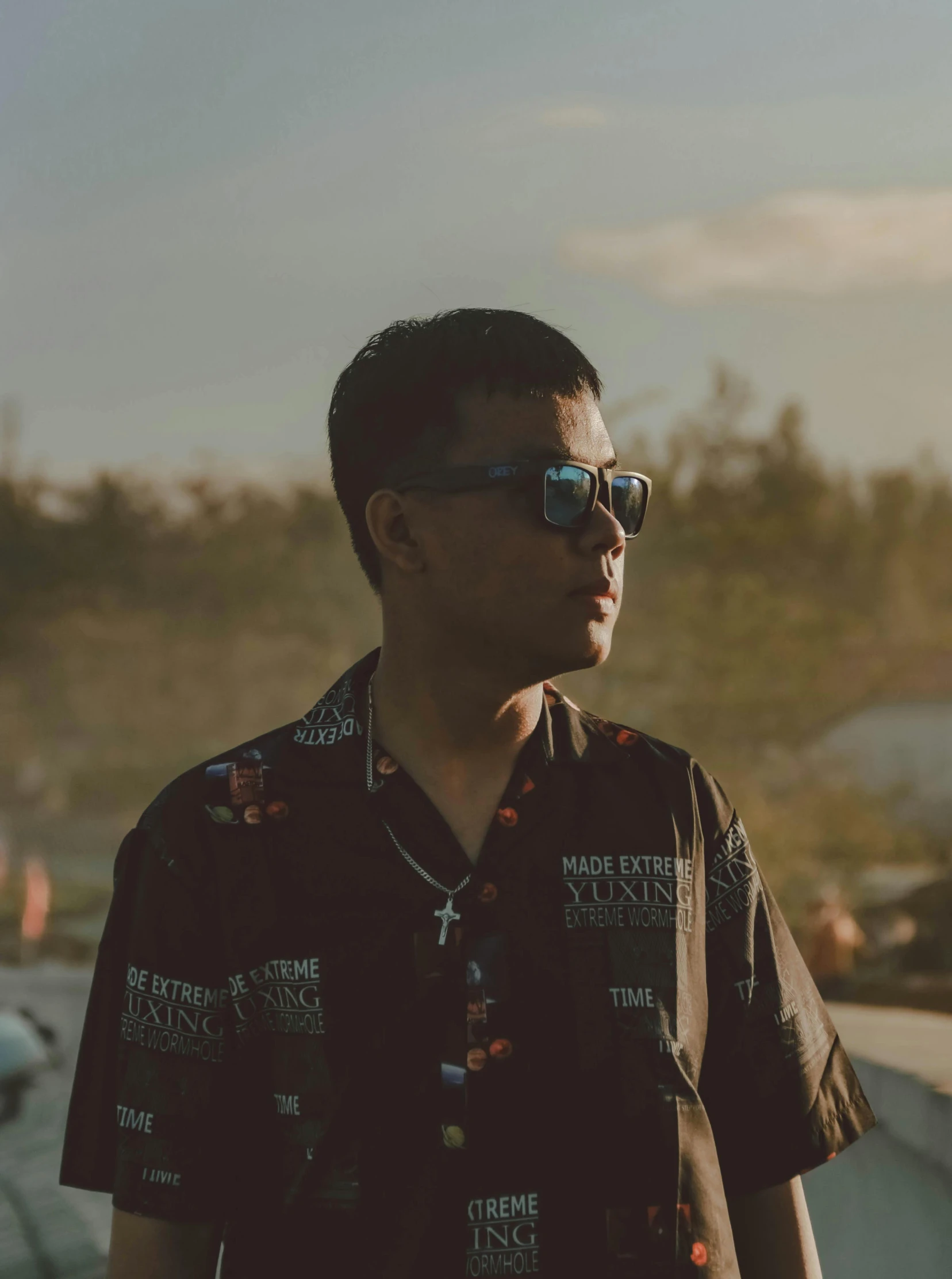 a man with sunglasses on standing near an ocean