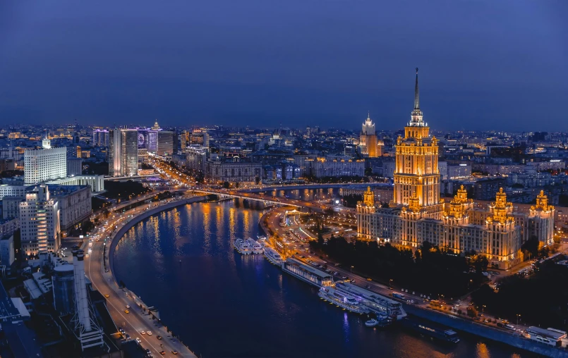 cityscape shows the bridge and large buildings at night