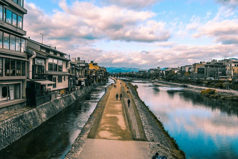 a man walking on the sidewalk next to the river