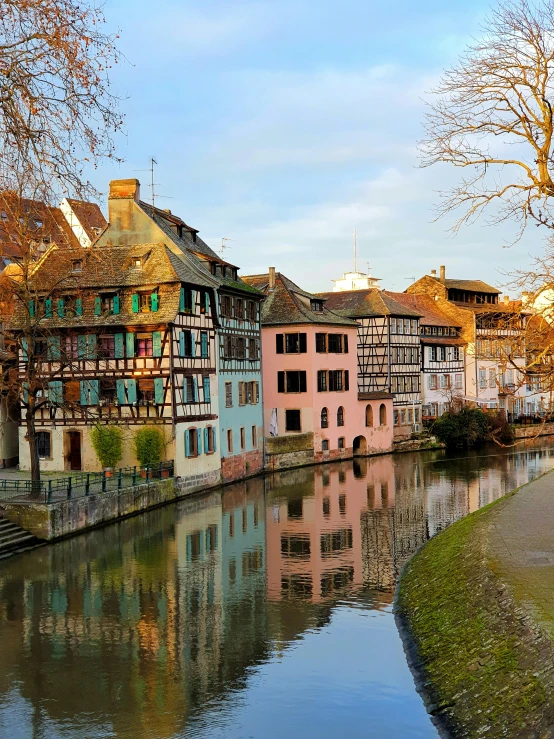 many colored buildings are reflected in a waterway