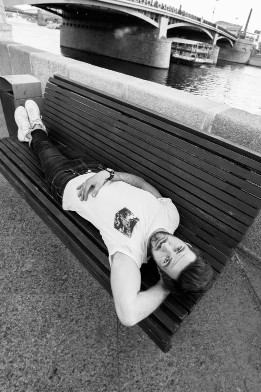 a man who is laying on top of a bench