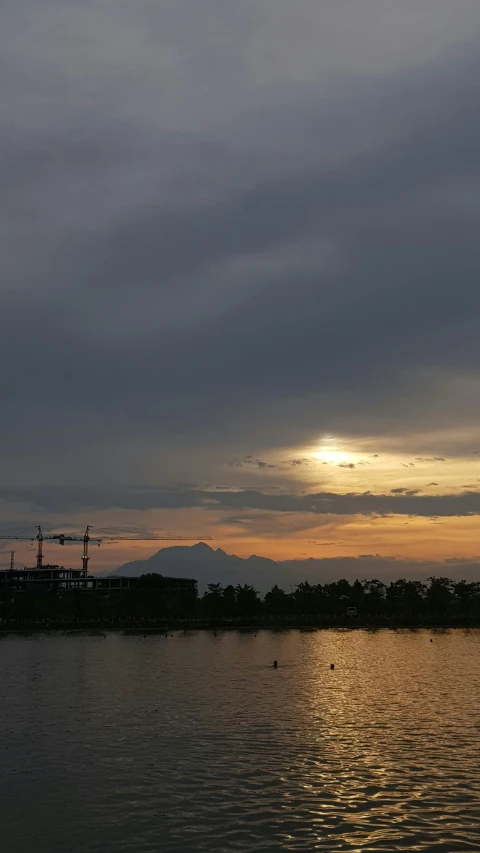 an image of a setting sun over a harbor