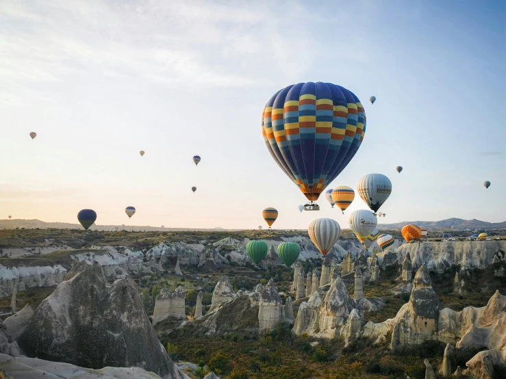 many different colored  air balloons over rocks