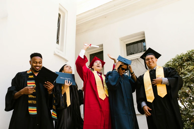 some graduating students pose in the doorway and wave