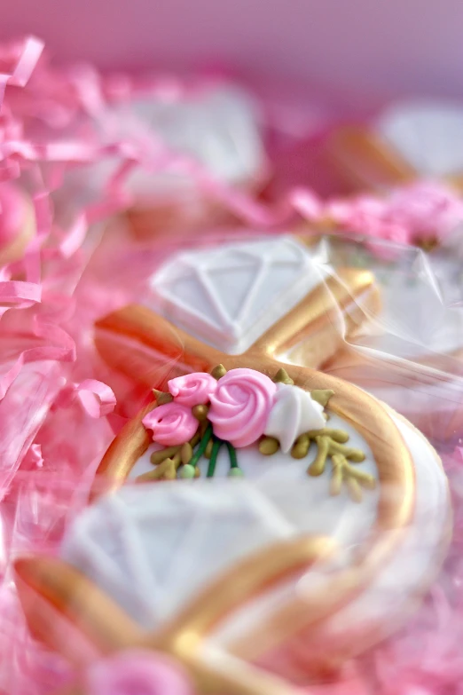 a closeup of decorated cookies, pink flowers and powder