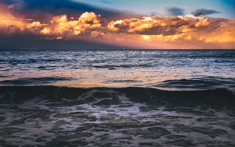 water is shown with some clouds and the sun