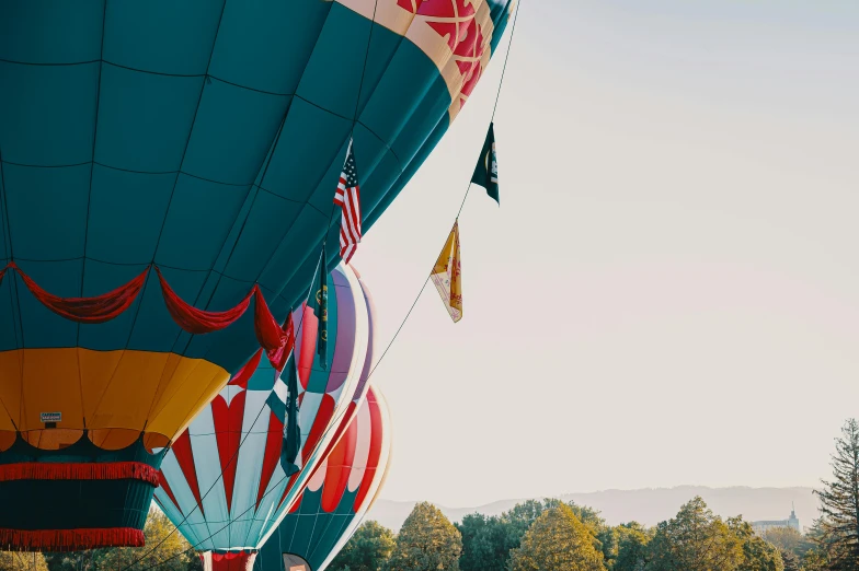 two  air balloons with flags flying in the sky