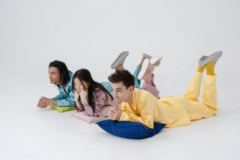 three people laying on the floor with shoes in the air