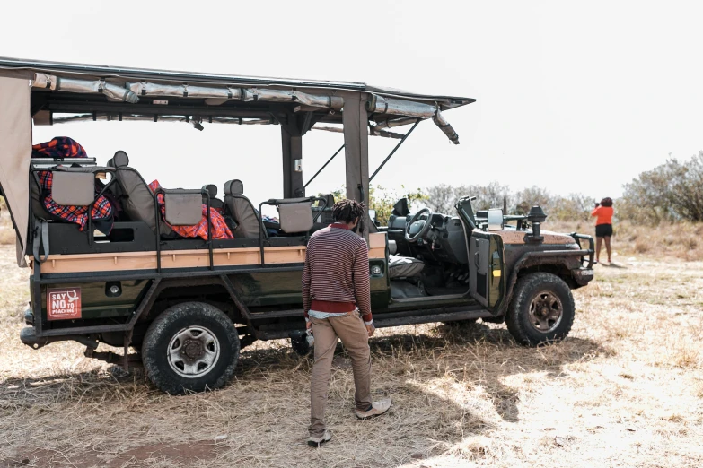 people standing in a field watching a vehicle