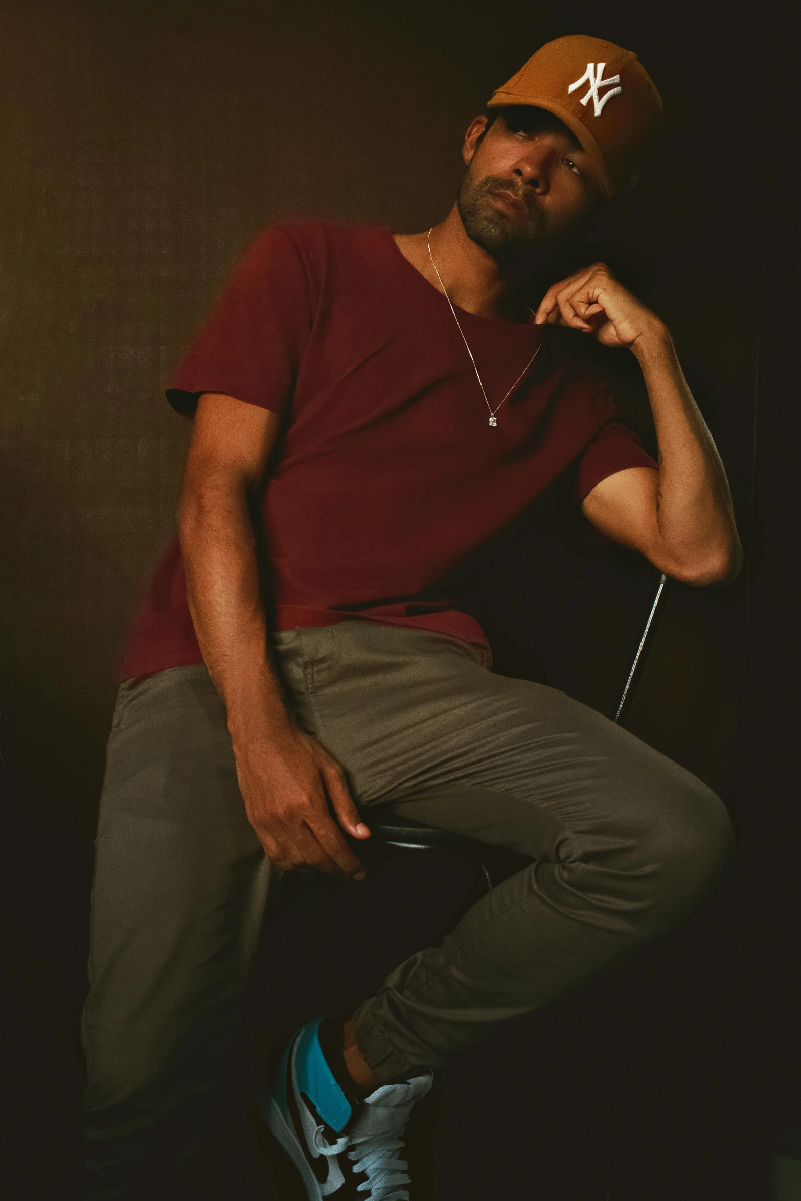 a young man in a red shirt sitting on a stool