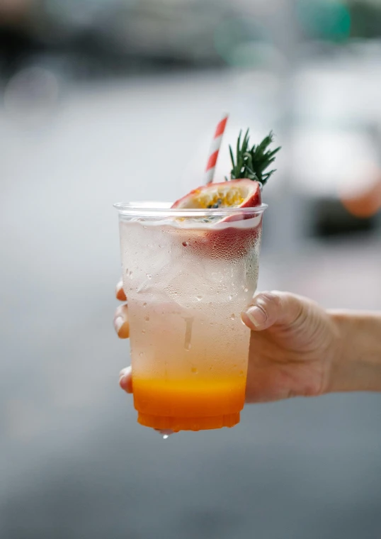 a person holding a cup with a drink