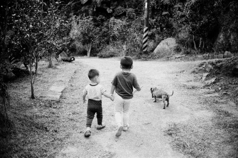 two small children running across a grass field