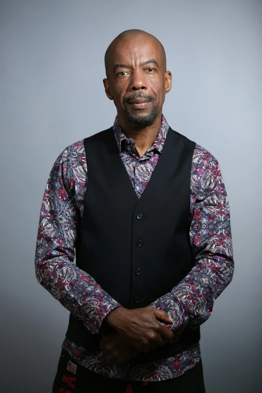 a man wearing a vest and a flowered shirt