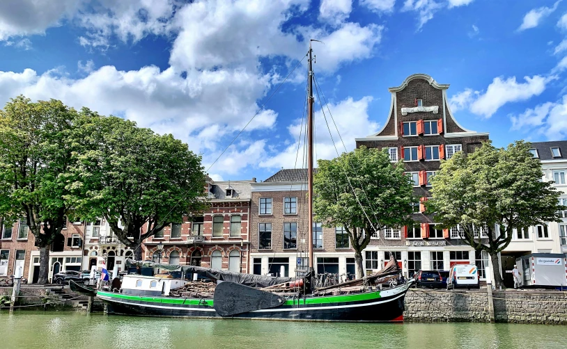 the boats are docked at the dock next to the buildings