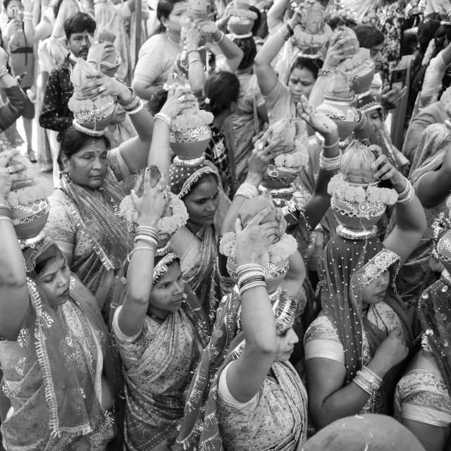 some indian women in saris holding up cups