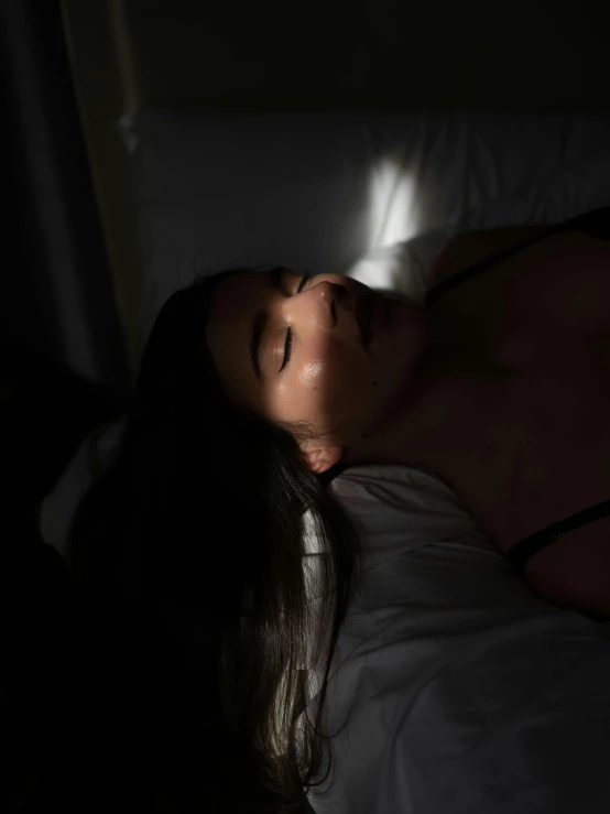 a beautiful young woman laying in a bed