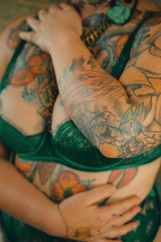 a man covered with tattoos holds his hand on his chest