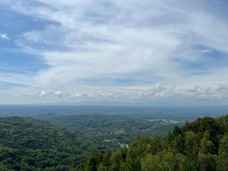 a bench at the top of a mountain overlooking a lush valley and trees