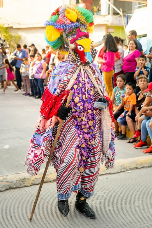 an oriental man is wearing colorful attire and holding a stick