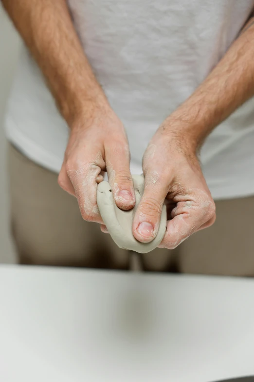 a man kneading dough on a table