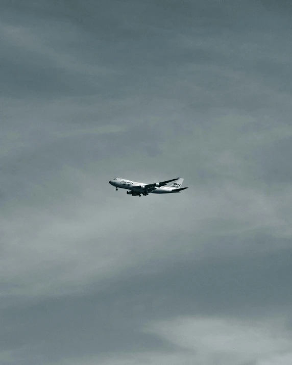 an airplane flies through the sky in black and white