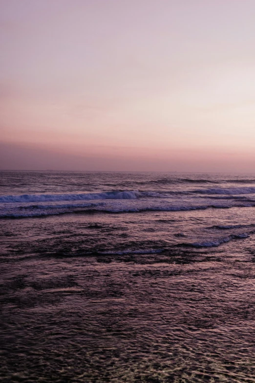 the ocean with waves coming in at sunset