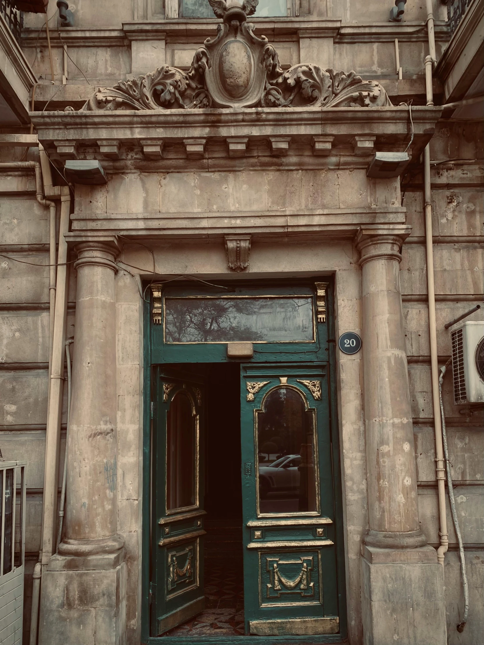 a large brick building with a door and green entryway