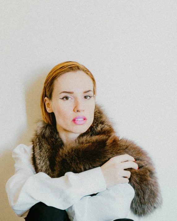 a woman with a fur collar blowing pink bubbles