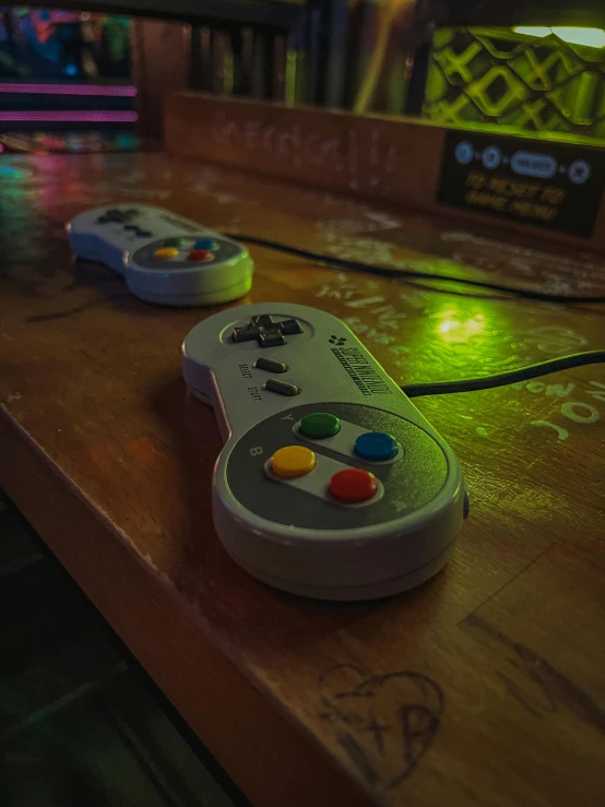two nintendo wii game controllers on a wooden table