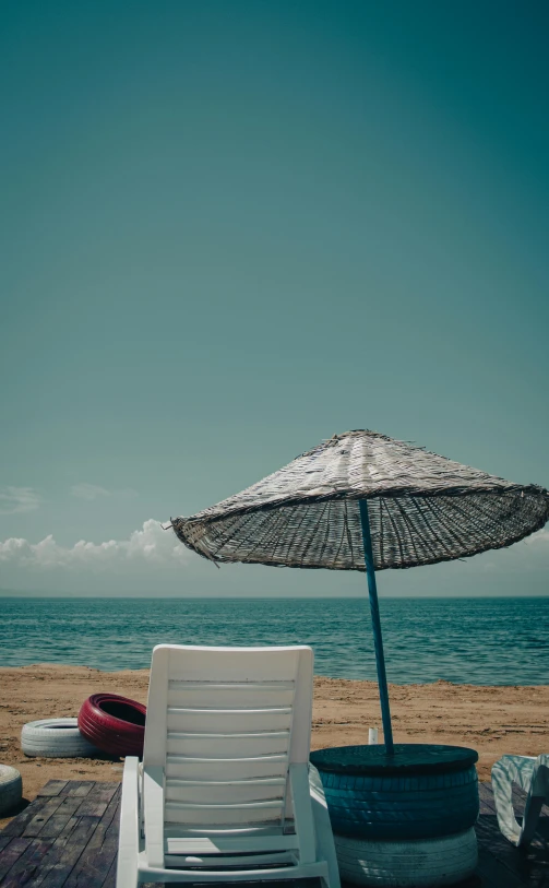 a chair and an umbrella sit on the beach