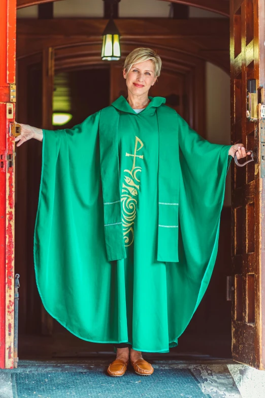 a woman dressed in green stands in the doorway of an ornate building