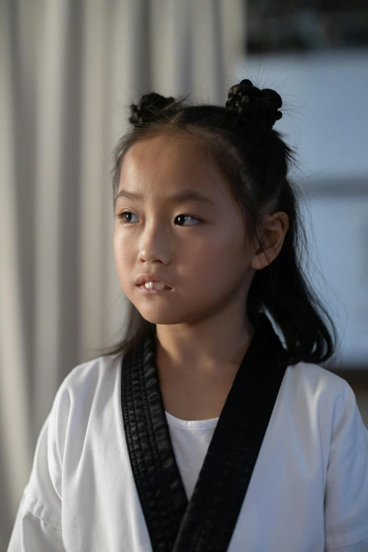 young woman wearing black belt next to a window