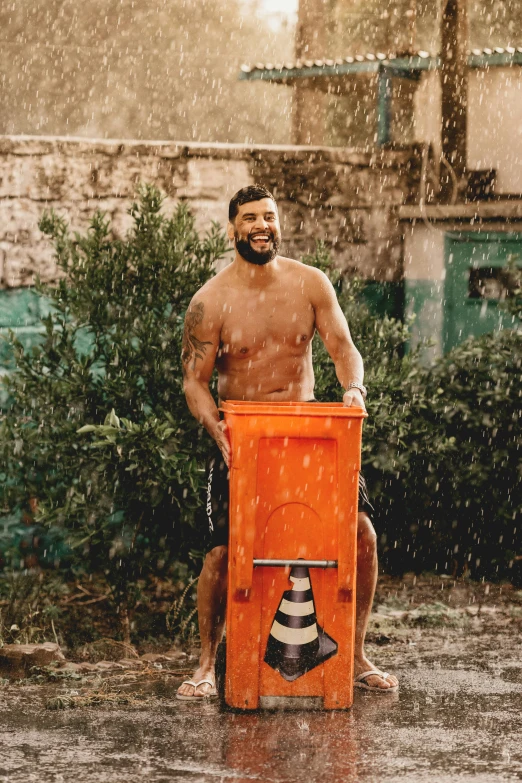 a man with  sitting in an orange bucket