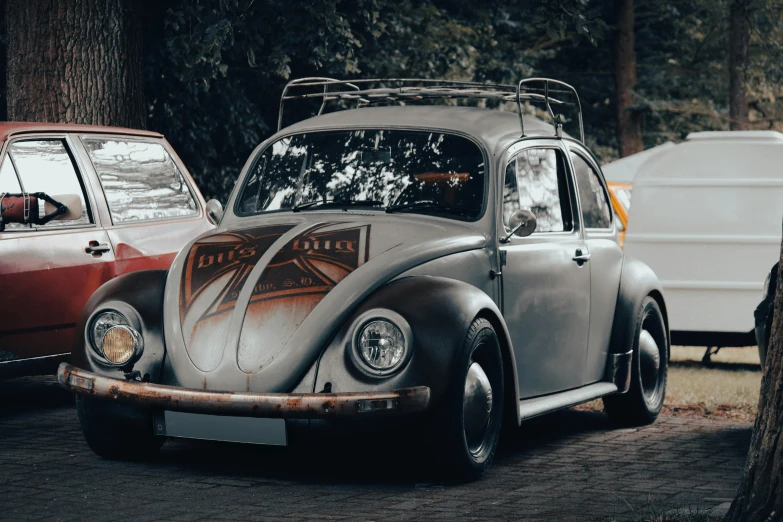 an old volkswagen beetle with a surf board on the back