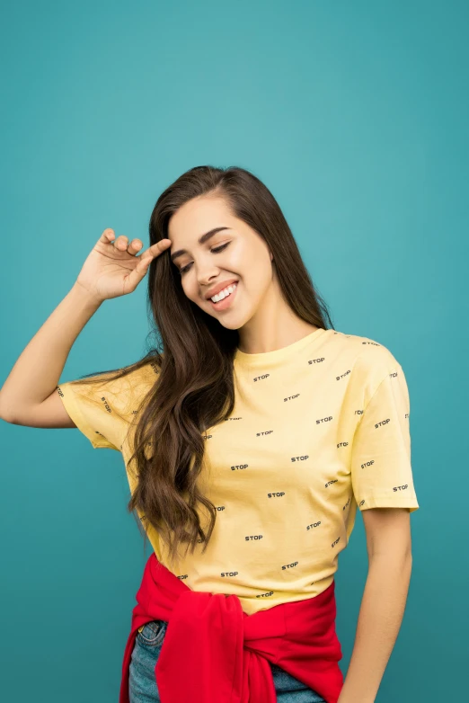 a woman smiles while putting her hand on her head