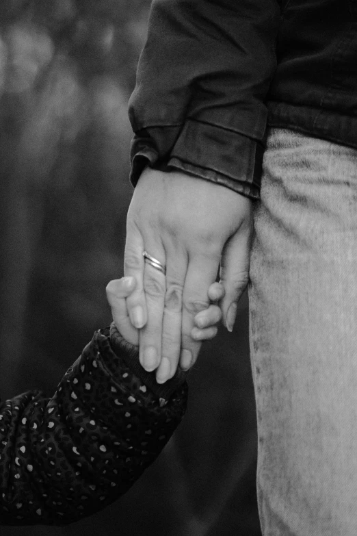 black and white pograph of two people holding hands