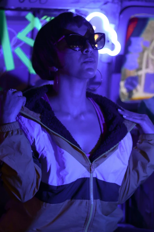a woman in sunglasses stands wearing an upcycle jacket
