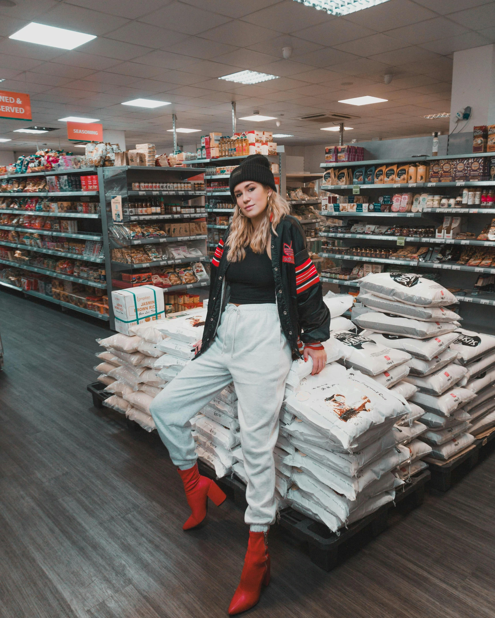 a woman in a black shirt and white pants in a supermarket