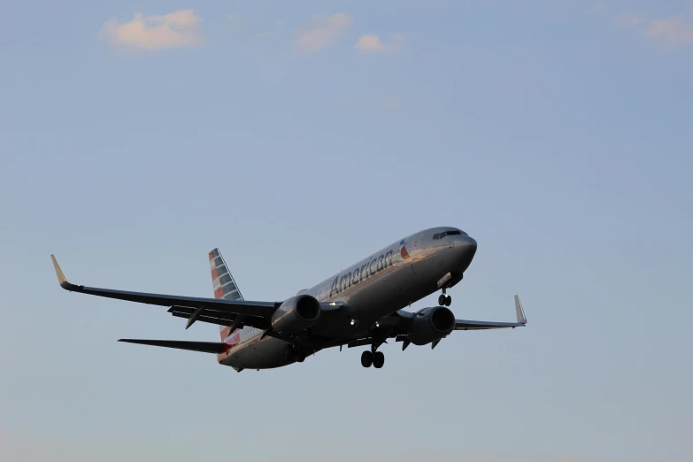 an airplane flies in the sky above on its wheels