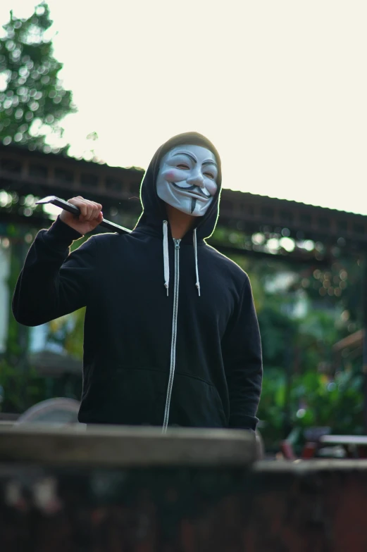 a man with a smiley face is dressed in a mask and holding a cigarette